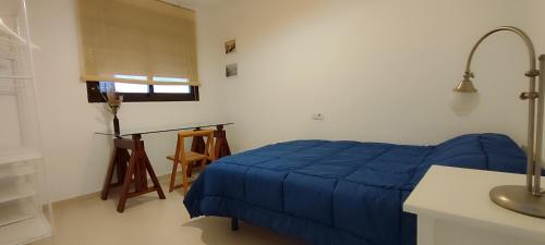 a bedroom with a blue bed and a sink at Casa Altaona in Sucina