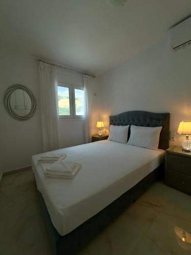 a bedroom with a large white bed with a window at Filocsenia luxury suite in Tsoutsouros