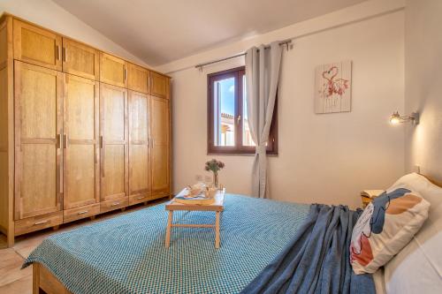 een slaapkamer met een bed, houten kasten en een tafel bij HD Apartment San Teodoro Center in San Teodoro
