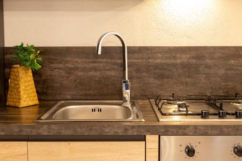 een gootsteen met een kraan naast een fornuis bij HD Apartment San Teodoro Center in San Teodoro