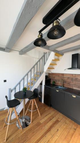 une cuisine avec un escalier, une table et des chaises dans l'établissement Le Gris métal, T2 duplex centre ville historique, à Bourges