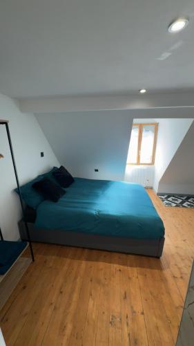 - une chambre avec un lit vert dans une pièce dotée d'une fenêtre dans l'établissement Le Gris métal, T2 duplex centre ville historique, à Bourges
