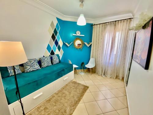 a bedroom with blue walls and a blue couch at Appartement B living in Agadir