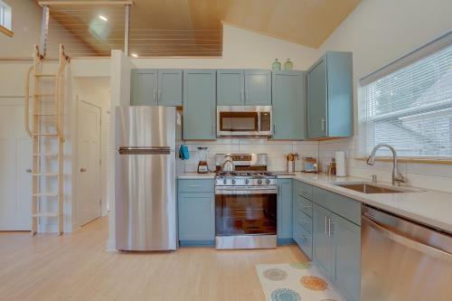 a kitchen with blue cabinets and a stainless steel refrigerator at Mod Pod in Bend