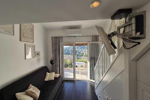 un salon avec un canapé et une porte coulissante en verre dans l'établissement Beautiful apt with balcony in Cavalaire-sur-Mer, à Cavalaire-sur-Mer