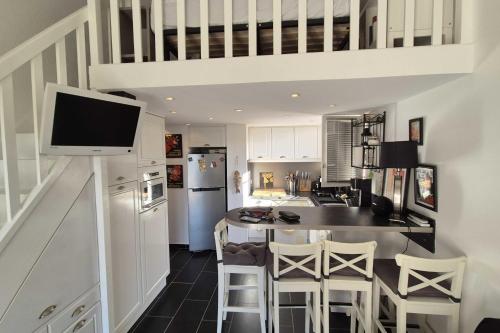 une cuisine avec une table avec des chaises et une télévision dans l'établissement Beautiful apt with balcony in Cavalaire-sur-Mer, à Cavalaire-sur-Mer