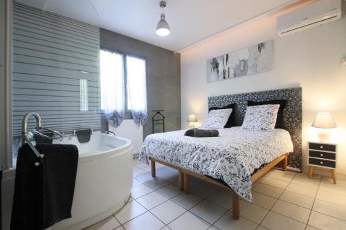 - une chambre avec un lit, une baignoire et un lit dans l'établissement Magnifique villa avec piscine, à Carcassonne