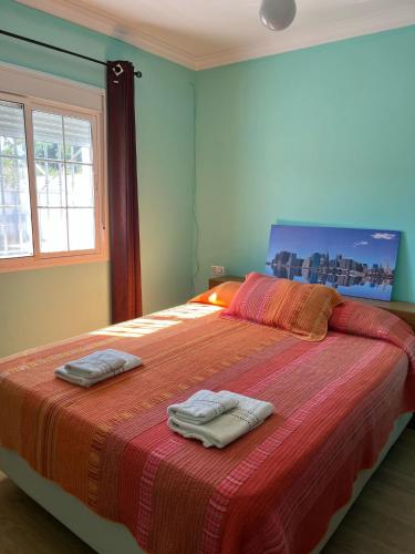 a bedroom with a large bed with two towels on it at Chalet Grande Margarita, 75 in El Puerto de Santa María