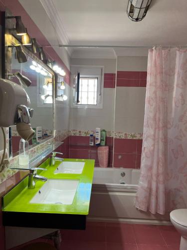 a bathroom with a green sink and a tub at Chalet Grande Margarita, 75 in El Puerto de Santa María