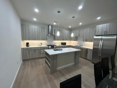 a large kitchen with a refrigerator and a sink at Brand New Spacious Tonwhome 3br 3ba sleeps 9 in Redwood City