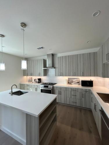 a large kitchen with white counters and a sink at 912 Brand New Spacious Tonwhome 3br 3ba sleeps 9 in Redwood City