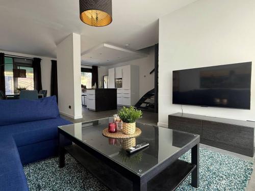 a living room with a blue couch and a table at Modern 3BR House in Central Nuenen in Nuenen
