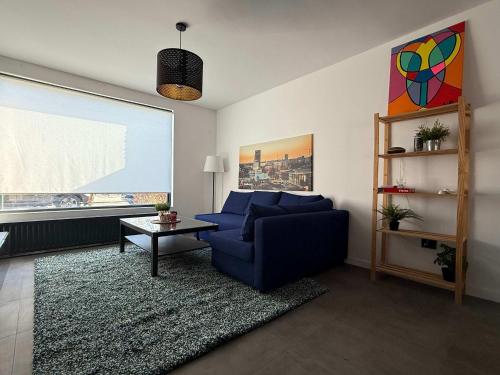 a living room with a blue couch and a table at Modern 3BR House in Central Nuenen in Nuenen