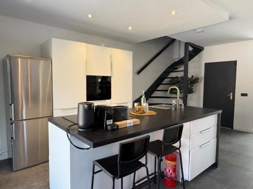 a kitchen with a black counter top and a refrigerator at Modern 3BR House in Central Nuenen in Nuenen