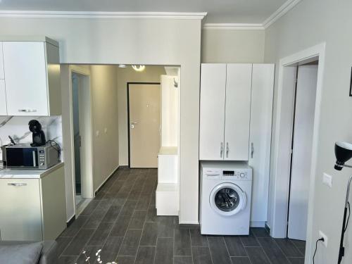a kitchen with a washing machine in a room at Azure Sands Golem in Golem