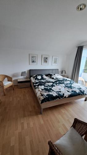 a bedroom with a bed and a wooden floor at Ferienhäuser Rhön - Haus Natalie & Haus Helene in Hausen