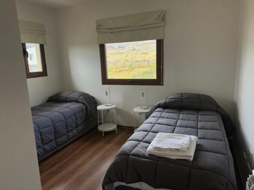 una camera da letto con due letti e una finestra di Lenga Hogar a El Calafate