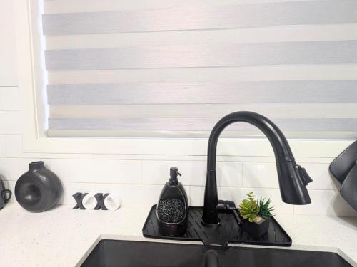 a kitchen sink with a black faucet at Edith Gate Luxe Bedroom 2 Homestay in Calgary