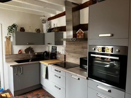 une cuisine avec des armoires blanches et un four à plaques de cuisson dans l'établissement Maison Chez ACHILLE, à Évreux