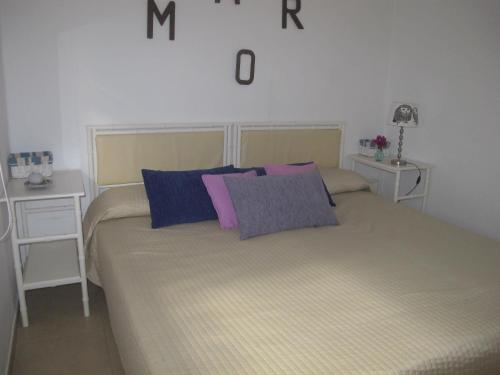 1 dormitorio con 1 cama con almohadas moradas y azules en Auremar en Puerto del Carmen
