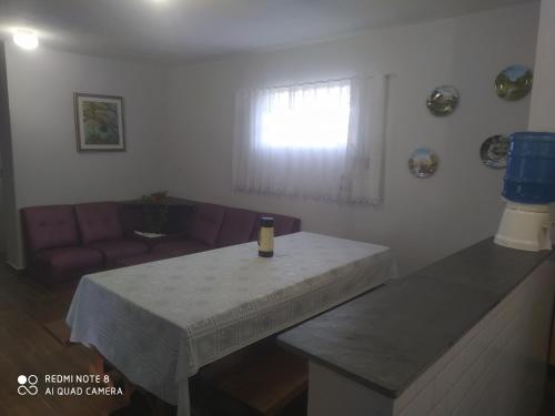 a living room with a table with a wine bottle on it at Chacara porta do mundo in Suzano