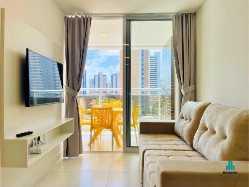 a living room with a couch and a television at Aquarius Style by Holiday Stays in Fortaleza