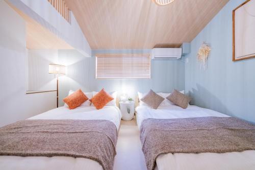 two beds in a room with blue walls at おそば 露天風呂でリラックス ベッド7台 usjへ11分 商店街に位置するお宿 in Osaka