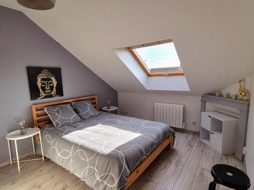 une chambre avec un lit et une lucarne dans l'établissement Les Nids de Montluçon, à Montluçon