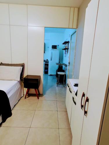 a bedroom with a bed and a kitchen with a table at Loft Centro de Florianópolis apart inteiro in Florianópolis