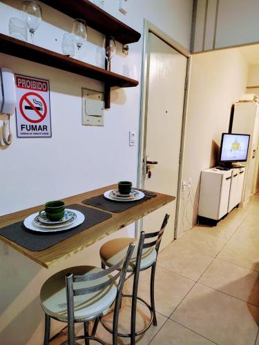 a kitchen with a table and chairs and a refrigerator at Loft Centro de Florianópolis apart inteiro in Florianópolis