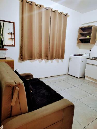 a living room with a couch and a kitchen at Loft Centro de Florianópolis apart inteiro in Florianópolis