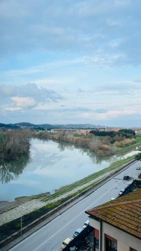 a view of a river with cars parked next to a road at Skyscraper Apartment Pontedera in Pontedera