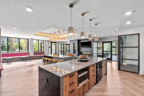a kitchen with a large island in a room with windows at Luxury Apartments by Hyatus Boston Somerville in Somerville