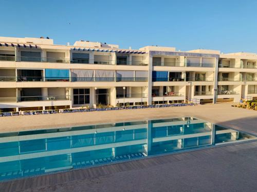 a building with a swimming pool in front of it at Élégance et Sérénité Vue Mer Panoramique et Piscine Privée in Agadir