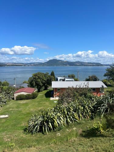 a house with a view of the water at Rotorua Lakes Cottage in Rotorua