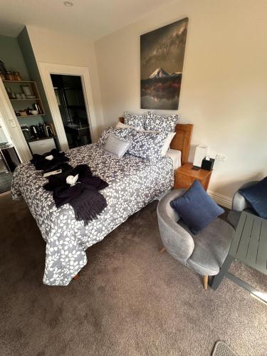 a bedroom with a bed and a chair at Two Rivers Ohakune - Boutique Bed and Breakfast in Ohakune