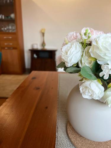 a white vase with a bouquet of flowers on a table at Skyscraper Apartment Pontedera in Pontedera