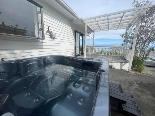 a bath tub sitting outside of a house at Tiro Tai - Coastal Views in Tahunanui