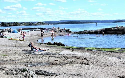a group of people on a beach near the water at Villa Kristiania in Oslo
