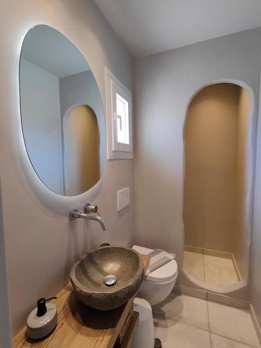 a bathroom with a sink and a toilet and a mirror at Avissalou Apartments in Agios Romanos