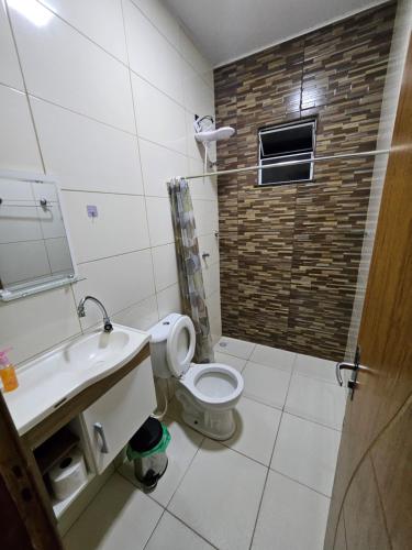 a bathroom with a toilet and a sink and a shower at Apto dois quartos com suíte e varanda in Belém