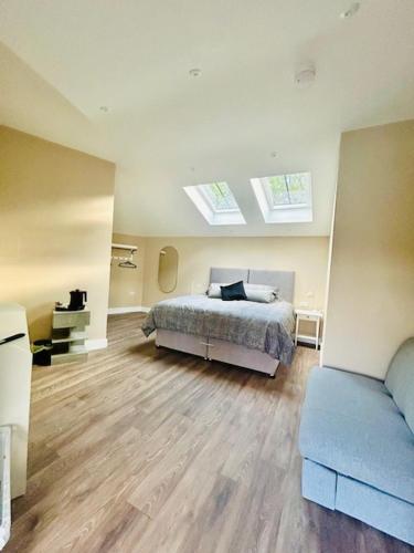 a bedroom with a bed and a blue couch at The Bear inn in Llantrisant