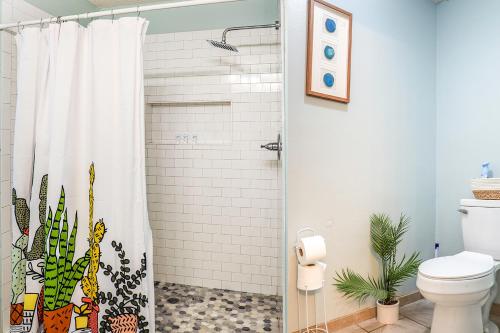 a bathroom with a shower with a cactus shower curtain at Pool House, Short Drive to Beach, Grill, Smart TV in Navarre