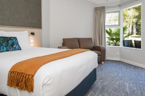 a hotel room with a large bed and a window at Copthorne Hotel & Resort Bay Of Islands in Paihia