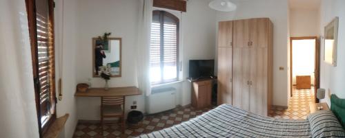a living room with a bed and a table and window at Il Pozzo Della Citerna in Castelnuovo Berardenga