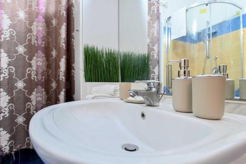 a bathroom with a white sink and a mirror at Giardino dei Libri - San Giuliano Milanese - by Host4U in San Giuliano Milanese