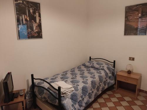 a bedroom with a bed and a table with a tv at Il Pozzo Della Citerna in Castelnuovo Berardenga