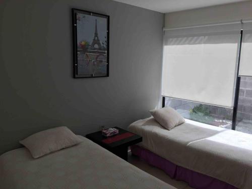 a room with two beds and a window and a picture at The Family House in Santa Rita