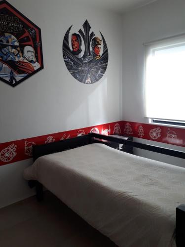 a bedroom with a bed and two posters on the wall at The Family House in Santa Rita
