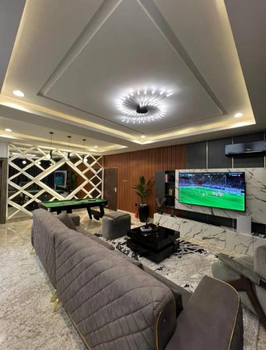 a living room with a couch and a large screen tv at Rosprot in Jiru